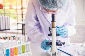 Closeup Woman scientist hand use dropper in lab look at science microscope medical test, research...
