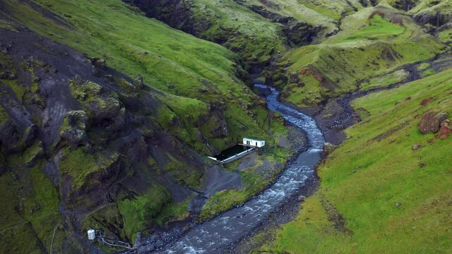 Aerial View Of Famous Seljavallalaug Swimming Pool On Foothill Of Mountain With River In Iceland.