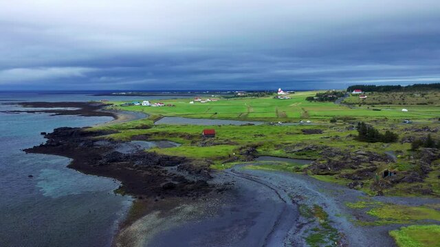Aerial View Of Rugged Coastline With Green Fields Near Gardakirkjugardur In Gardabaer, Iceland.