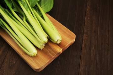 木製テーブルにあるまな板の上の小松菜