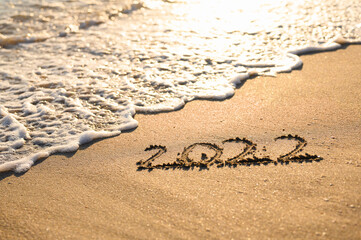 New Year 2022 on the shore. Written with a finger. Selective focusing.