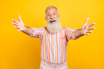 Naklejka premium Photo of funny friendly age gentleman wear striped shirt smiling open arms inviting hugging isolated yellow color background