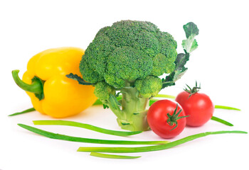 Vegetables on the white background - broccoli, tomatoes, cucumbers and green onions. Composition of vegetables on the white background