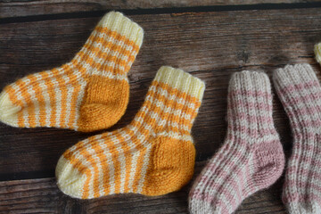 New vintage woolen baby socks on dark wooden background