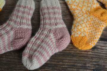 Fototapeta na wymiar New vintage woolen baby socks on dark wooden background