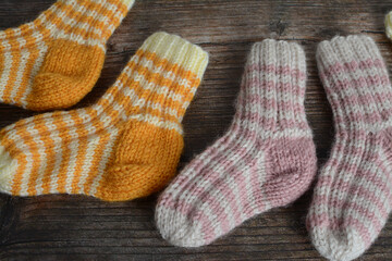 New vintage woolen baby socks on dark wooden background