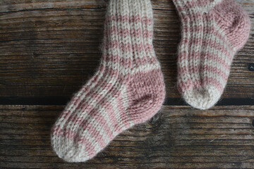 New vintage woolen baby socks on dark wooden background