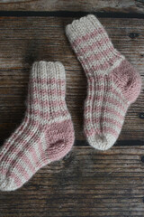 New vintage woolen baby socks on dark wooden background