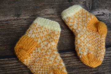 New vintage woolen baby socks on dark wooden background