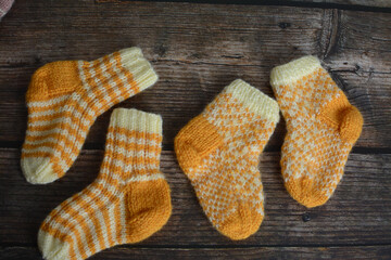 New vintage woolen baby socks on dark wooden background