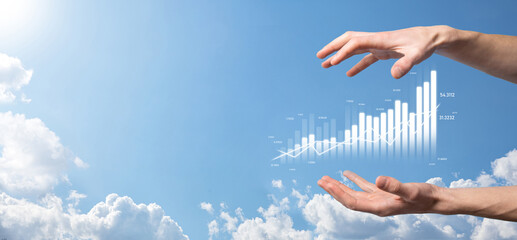 Business man holding tablet and showing holographic graphs and stock market statistics gain profits. Concept of growth planning and business strategy. Display of good economy form digital screen.