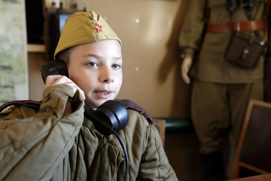 Child in uniform of red army with telephone receiver