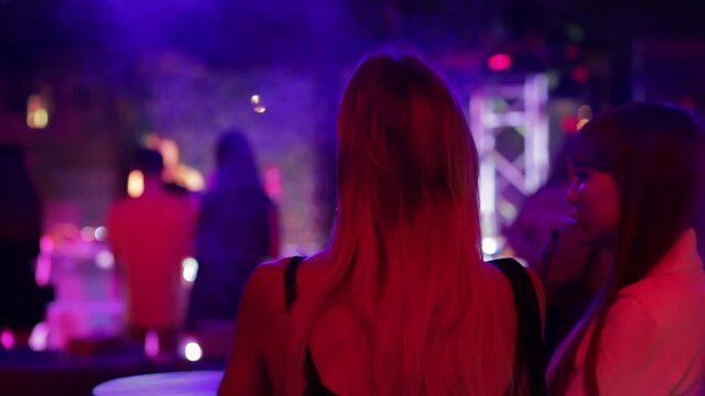 Young ladies smokes hookah in nightclub
