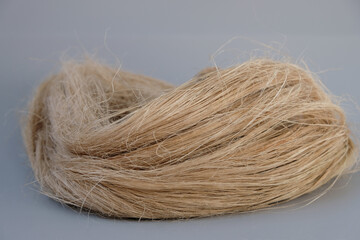 Fibers of natural uncolored flax or hemp, tow, close-up. Growing demand for natural fibers.