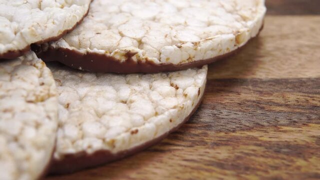 Puffed rice bread with chocolate on a wooden surface. Macro. Dolly shot