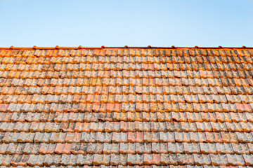abstract background of an old red tiled roof against a bright blue sky