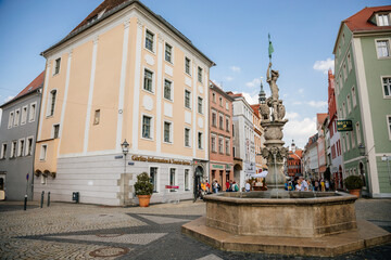 Fototapeta na wymiar Goerlitz, Saxony, Germany, 04 September 2021: Georgsbrunnen or George's fountain at Obermarkt or Upper market, picturesque street with renaissance baroque historical buildings at summer sunny day