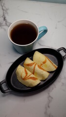 pinapple jam filled pancakes served with a cup of hot tea.