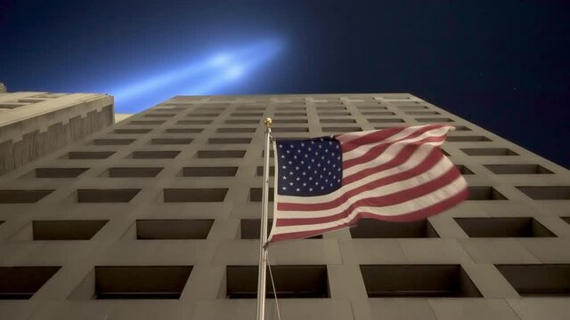 American Flag Waving On Building In NYC Under September 11th Memorial Lights
