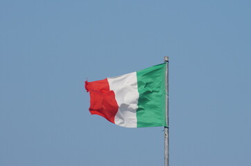 Fototapeta na wymiar Flag of Italy with the colors: red, white, green, moved by the wind with the sky background