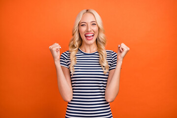 Portrait of attractive cheerful lucky satisfied girl rejoicing having fun isolated over bright orange color background