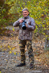 professional photographer in camouflage clothes working in nature.