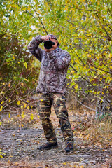 Fototapeta na wymiar professional photographer in camouflage clothes working in nature.