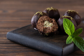 Chocolate truffles stuffed with mint and matcha on a brown wooden board. Sugar, gluten and lactose...