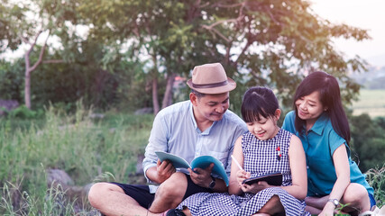 A lovely family is using a tablet to study online outside of the classroom.Educational technology concept