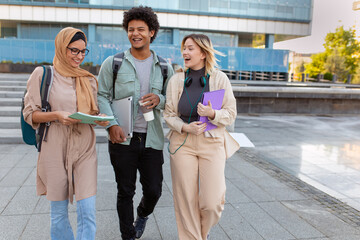 Fototapeta premium Group of diverse students outside smiling together and walking