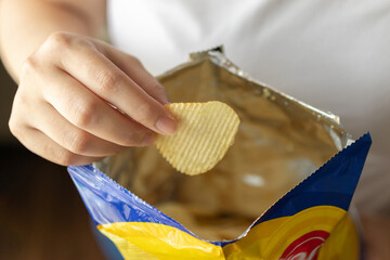 Hand hold potato chips with snack bag