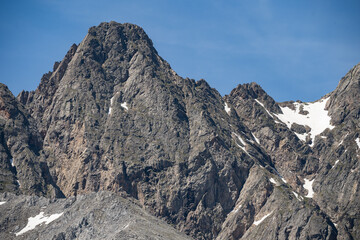 Rocky mountain range against a clear blue sky. Lots of stones. Close-up