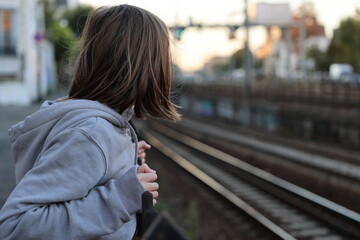 Girl watching a railway in France at sunset