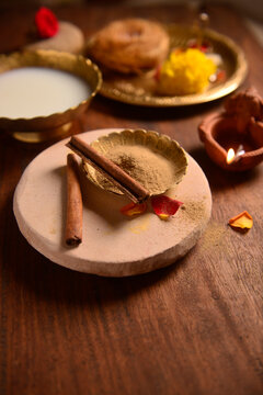 Organic sandalwood and spiced herbal powder for special therapeutic bath on special occasions like Diwali festival or weddings. Diwali 'Abhyang Snan' ritual background.