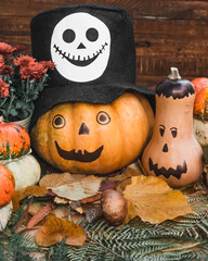 Orange ghost pumpkins on wooden background. Halloween holiday concept.