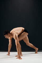 Fototapeta na wymiar male bodybuilder in black shorts on a dark background