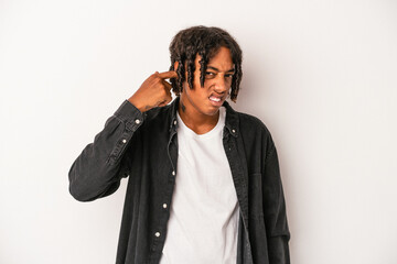 Young african american man isolated on white background covering ears with hands.