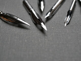 Drawing pens, fountain pens with different nibs on a textured surface