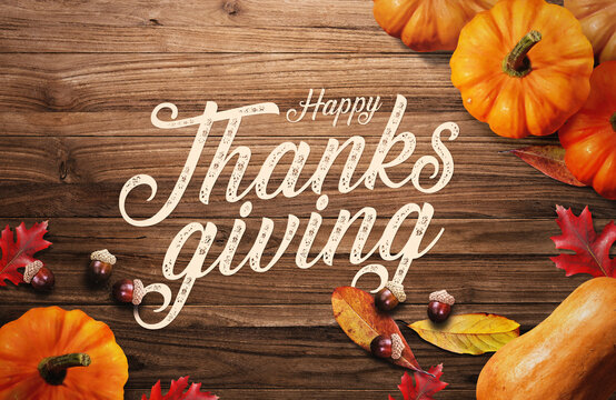 Happy Thanksgiving on Wooden Background with pumpkins and autumn leaves