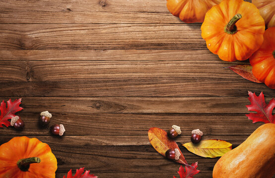 Pumpkin and Autumn Leaves on Wooden Background