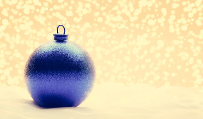 Glitter blue Christmas ball on snow