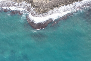 Fototapeta premium Aerial view of waves splashing on beach