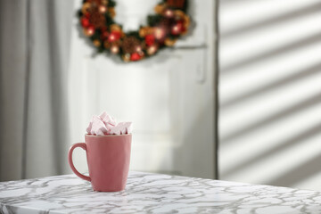 Christmas hot drink on a marble table against the background of festive white doors 