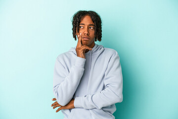 Young african american man isolated on blue background contemplating, planning a strategy, thinking about the way of a business.