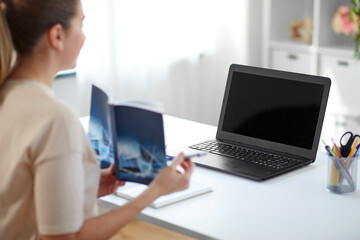 distant education, school and people concept - female math teacher laptop computer and book having online class at home