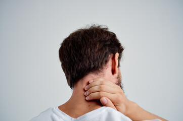 Fototapeta premium bearded man in a white t-shirt stress medicine pain in the neck light background