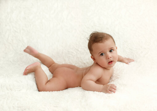Small kid lying on white background . Full view, side view. Baby massage .Development of a child up to a year. 