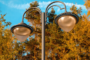 A double lantern in an old style against a background of bright blue sky and trees