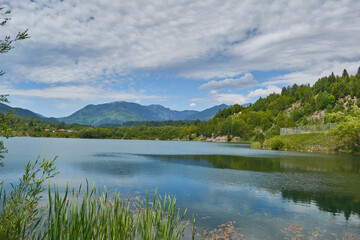 Landscape from Campu lui Neag Romania with lake mountain clouds blue sky and green forest