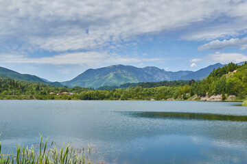 Landscape from Campu lui Neag Romania with lake mountain clouds blue sky and green forest